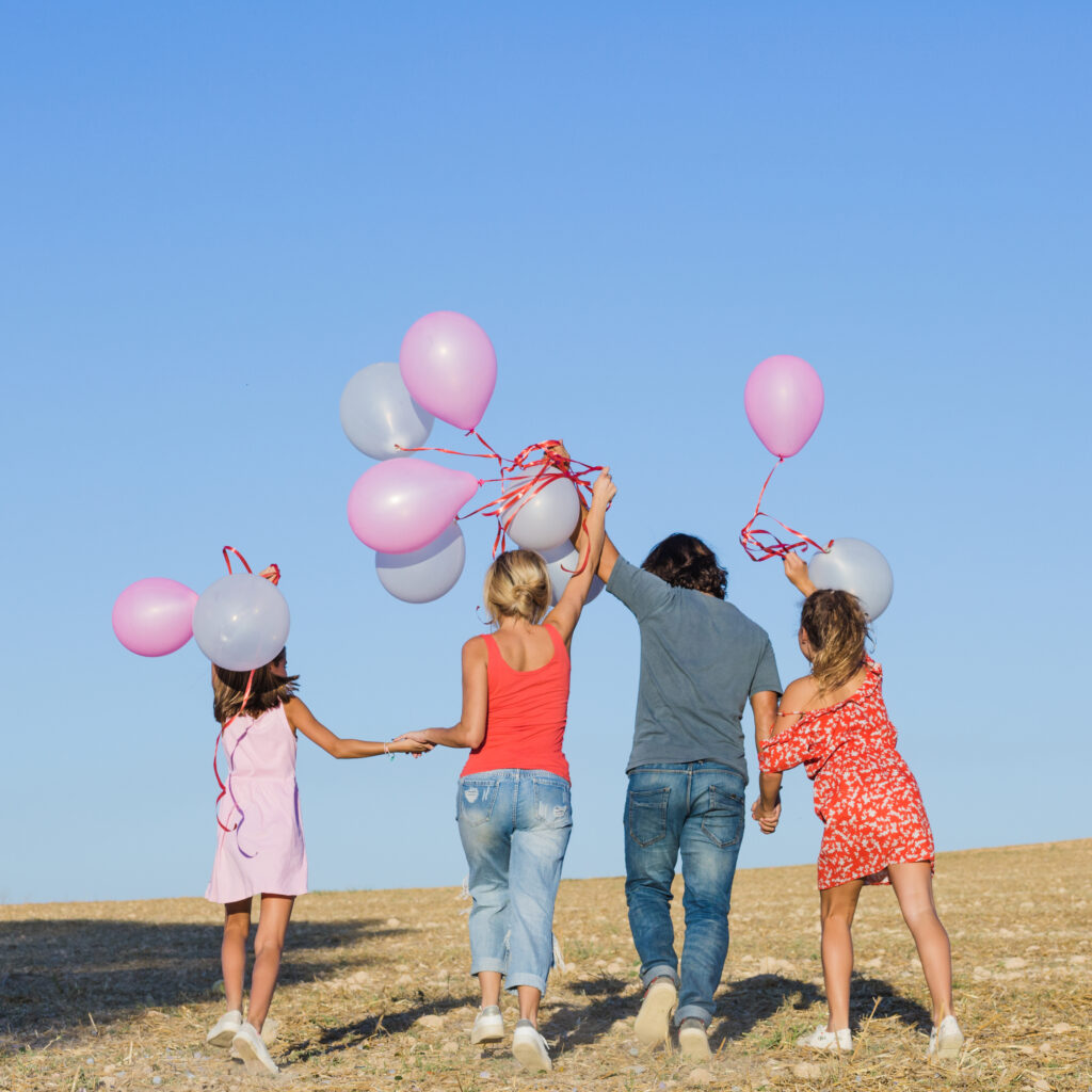family-walking-field-with-balloons